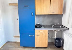 a blue refrigerator in a kitchen with a sink at Studioappartement voor 2 gasten - 33-45 in Bunkenburg