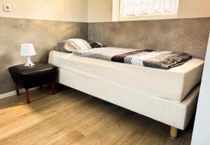 a large bed in a room with a table and a lamp at Studioappartement voor 2 gasten - 33-45 in Bunkenburg