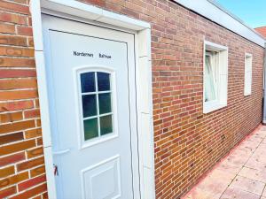 a white door on the side of a brick building at Studioappartement voor 2 gasten - 33-45 in Bunkenburg