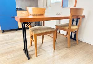 a wooden desk with two chairs and a kitchen at Studioappartement voor 2 gasten - 33-45 in Bunkenburg +4 photos