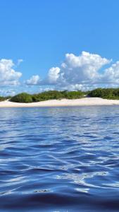 a body of water with an island in the distance at Chalé Portal das Lagoas in Santo Amaro
