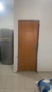 a wooden door in a room with a refrigerator at Chalé Portal das Lagoas in Santo Amaro
