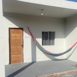 a hammock hanging on the side of a building at Chalé Portal das Lagoas in Santo Amaro