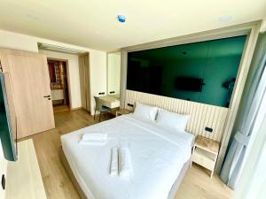 una camera da letto con un letto bianco con una grande finestra di THE OZONE CONDOMINIUM laguna near bangtao beach a Ban Nong Chaeng