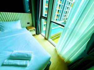 un letto con due asciugamani sopra in una stanza con finestra di THE OZONE CONDOMINIUM laguna near bangtao beach a Ban Nong Chaeng