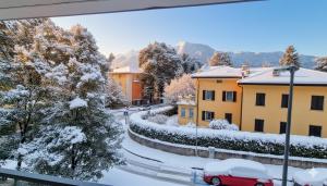 a red car driving down a snow covered street at -Parcheggio Privato-Riscaldamento Pavimento-WiFi- zona OSPEDALE-CENTRO "COZY PANoRAMA" in Trento