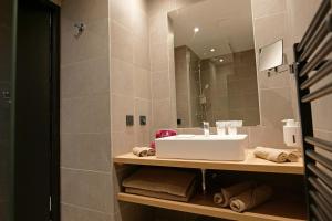 a bathroom with a sink and a mirror at Garrigae Caserne de Briançon & SPA Cinq Mondes in Briançon
