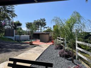 a bench in front of a yard with a fence at Doa Blanca Cabin Mountain View in Utuado +5 photos