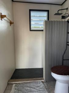 a bathroom with a toilet and a window at Doa Blanca Cabin Mountain View in Utuado