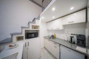 eine Küche mit weißen Schränken und einer Treppe in der Unterkunft Széchenyi Apartman Miskolc belvárosban in Miskolc