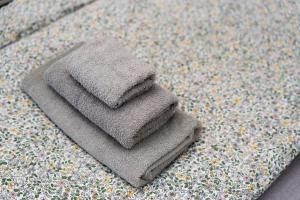 ein Stapel Handtücher auf einem Bett in der Unterkunft Széchenyi Apartman Miskolc belvárosban in Miskolc