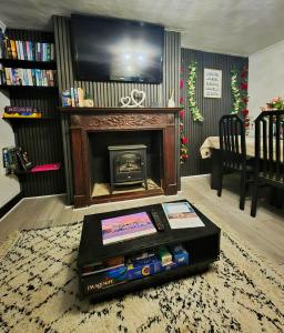 a living room with a fireplace and a table at Fox Haven in Bicester