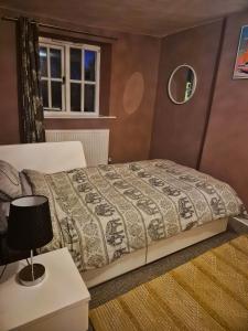 a bedroom with a bed and a table with a lamp at Fox Haven in Bicester