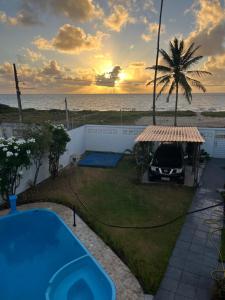 ein unter einem Pavillon mit einer Palme geparktes Auto in der Unterkunft Casa vista Mar, pé na areia com piscina ! in Pitimbu