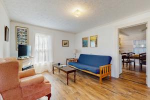 un soggiorno con un divano blu e un tavolo di Firefly Cottage a Sky Village