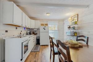 una cucina con frigorifero bianco, tavolo e sedie di Firefly Cottage a Sky Village