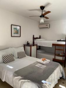 a bedroom with two beds and a ceiling fan at Pousada Marendaz in Paraty
