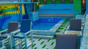 una piscina con sedie e tavolo di Proximus Hotel and Suites a Owerri