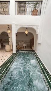 an indoor swimming pool in a house with a ceiling at Riad de charme privatisé au cœur de la médina in Oulad Akkou