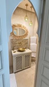 a bathroom with a sink and a mirror at Riad de charme privatisé au cœur de la médina in Oulad Akkou
