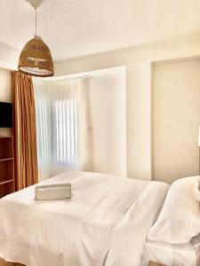 a bedroom with a white bed and a window at HS Altet Suites - Alicante Airport in El Alted
