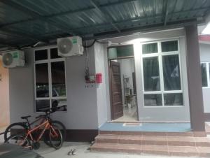 a house with two bikes parked outside of it at D'Yaya Homestay in Kampong Pengkalan Nyireh