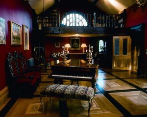 ein Wohnzimmer mit einem Klavier und einem Stuhl in der Unterkunft Moongate lodge in Killedmond