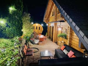 un patio avec un canapé, une table et des chaises dans l'établissement Villa Aurora, à Labaroche