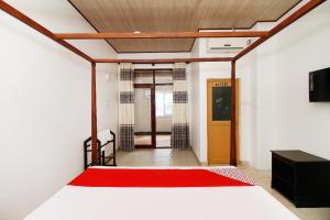 ein Schlafzimmer mit einem Bett mit einer roten Decke in der Unterkunft Royal Oshin Hotel in Wadduwa