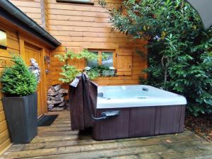 une grande baignoire assise sur une terrasse en bois dans l'établissement Villa Aurora, à Labaroche 24 autres photos