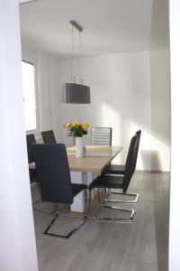 a dining room with a wooden table and black chairs at Apartment Valis in Velenje