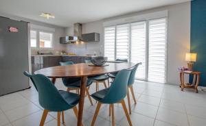 a kitchen with a wooden table and blue chairs at Le Fairway in Bréviandes +8 photos