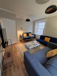 a living room with a blue couch and a table at 2 Courtyard Mews in Penzance
