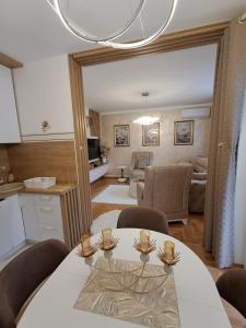 a kitchen and living room with a table and chairs at Apartman PETRA QUEEN in Plužine