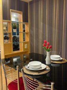 a dining room with a table with plates and flowers at Modern Suite near BTS Nana Netflix Sky View in Makkasan