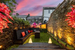 a garden with a stone wall and a bench at The Secret Garden, Donaghadee "The Hideaway" in Donaghadee