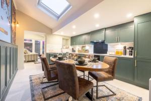 a kitchen with green cabinets and a wooden table and chairs at The Secret Garden, Donaghadee "The Hideaway" in Donaghadee