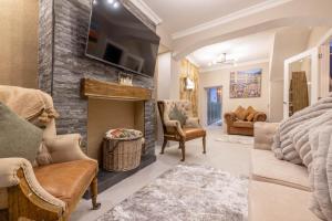 a living room with a fireplace and a tv at The Secret Garden, Donaghadee "The Hideaway" in Donaghadee