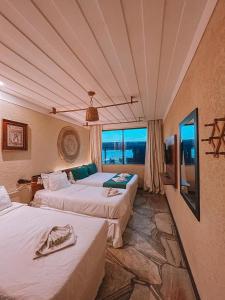 a bedroom with two beds and a large window at PIER BEACH CLUB in Cabo Frio