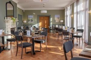 a restaurant with tables and chairs and a fireplace at Landal Kenwick Woods in Louth