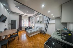 een keuken en woonkamer met een bank en een tafel bij Széchenyi Apartman (III. Panorama) Miskolc belvárosában in Miskolc