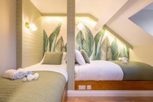 The Secret Garden, Donaghadee - The Hideaway - Guests 7 في Donaghadee: سريرين في غرفة نوم مع جدارية من الأوراق