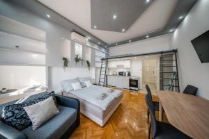 een woonkamer met een bank en een tafel bij Széchenyi Apartman (III. Panorama) Miskolc belvárosában in Miskolc