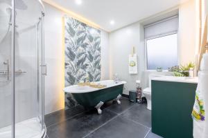 a bathroom with a green tub and a shower at The Secret Garden, Donaghadee "The Hideaway" in Donaghadee +88 photos