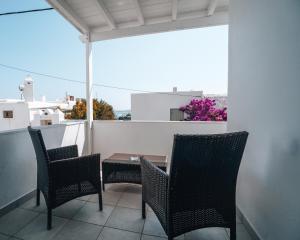 un patio avec deux chaises et une table sur un balcon dans l'établissement Alexandros Studios, à Náoussa