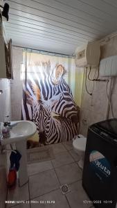 ein Badezimmer mit einem Zebra-Gemälde auf dem Duschvorhang in der Unterkunft Casa proxima a zona comercial in Rivera