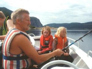 a man and two children in a boat on the water at 7 person holiday home in Foldereid-By Traum in Årfor