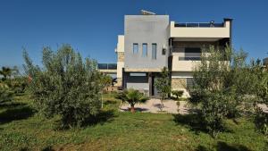 ein Gebäude mit Bäumen davor in der Unterkunft Villa confort in Oulad Tayeb