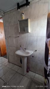 ein Badezimmer mit einem weißen Waschbecken und einem Spiegel in der Unterkunft Casa proxima a zona comercial in Rivera + 10 Fotos