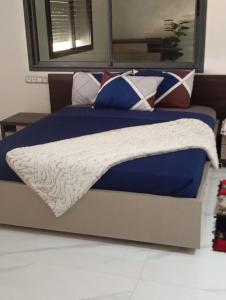 ein Bett mit einer blauen und weißen Bettdecke und Kissen in der Unterkunft Villa confort in Oulad Tayeb